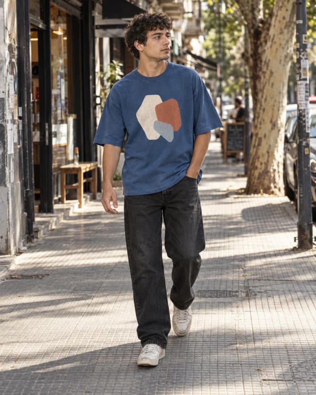 Joven con remera azul estampada caminando por la ciudad