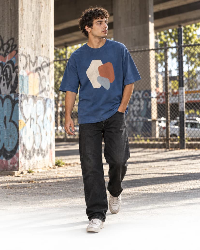 Joven con remera azul estampada caminando bajo un puente
